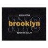 Urban style typography area rug with gold Brooklyn text on black background with white NYC outline