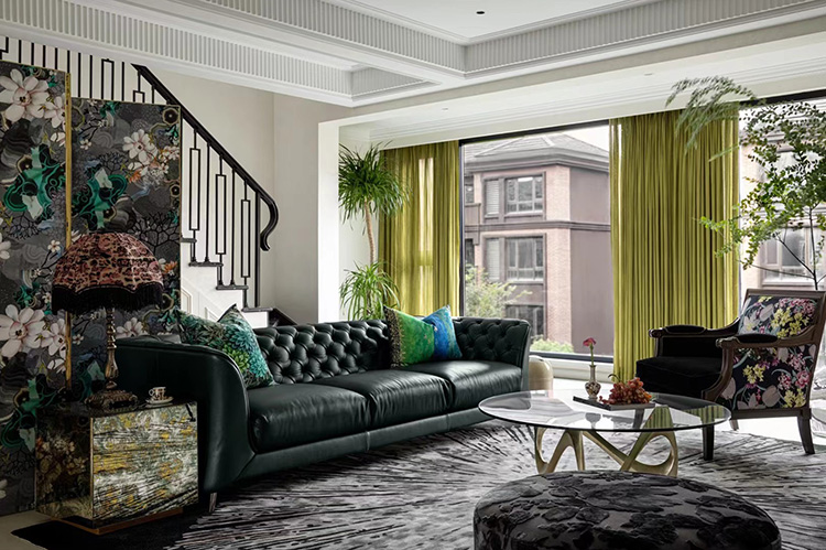 A customized hand tufted black round wool carpet with abstract white splashes, in front of a black sofa