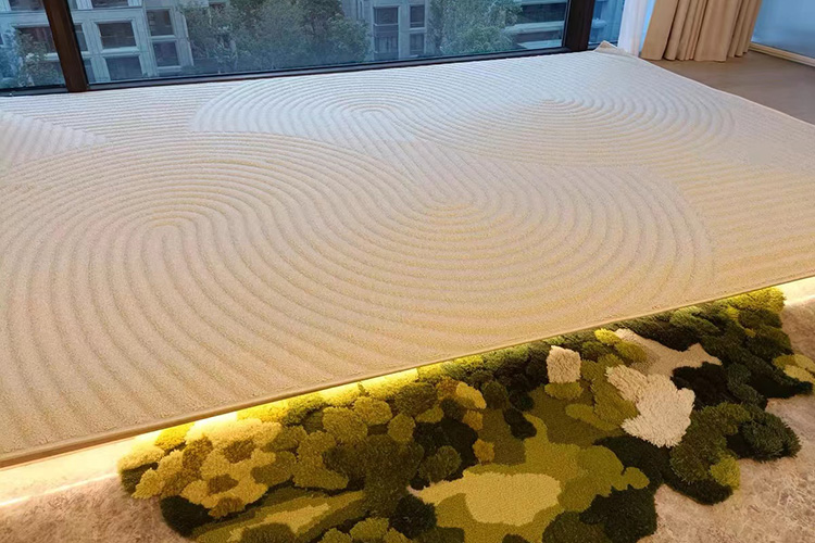 A beige hand tufted wool rug with carved circular lines above a green tufted wool moss rug near a window