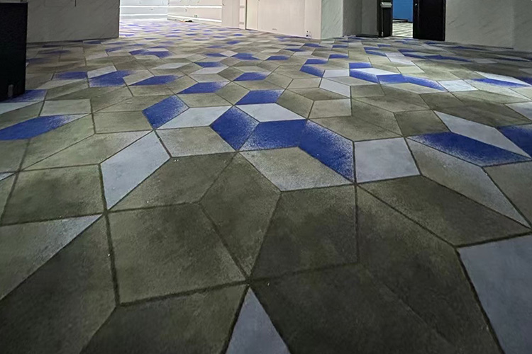 A durable hand tufted rug with bold green and blue square blocks, installed on the corridor of a movie theatre