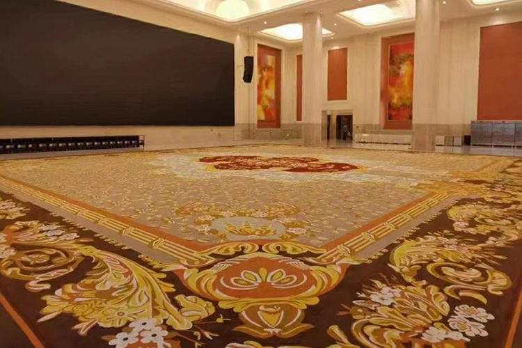 A large vintage red tufted carpet with floral motifs made from New Zealand wool, installed in a luxury hotel hall