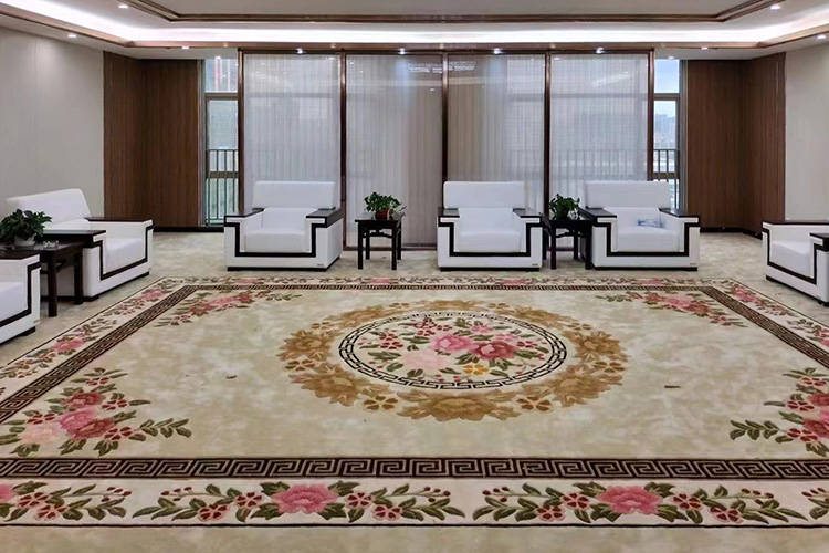 A beige vintage hand tufted wool rug with floral motifs, installed in a luxury modern meeting room