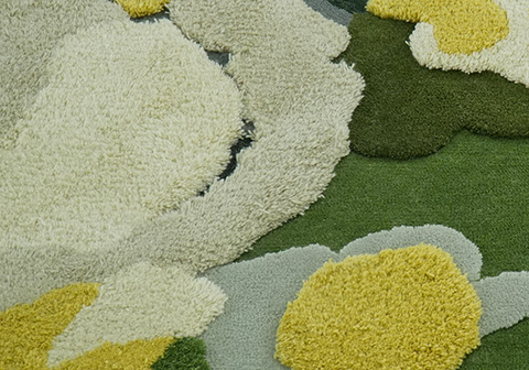 Acrylic tufted rug texture displaying smooth, clean-edged shapes in cream, yellow, sage, and forest green moss patterns