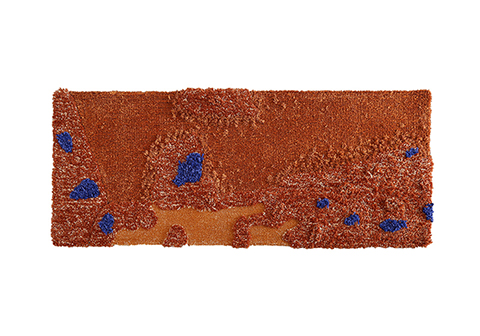 Long rectangular tufted rug in rich caramel brown tones with scattered blue crystal-like accents