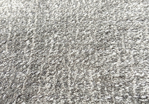 Cut-pile tufted rug texture showing plush, upright yarn strands in silver gray creating a soft, luxurious surface