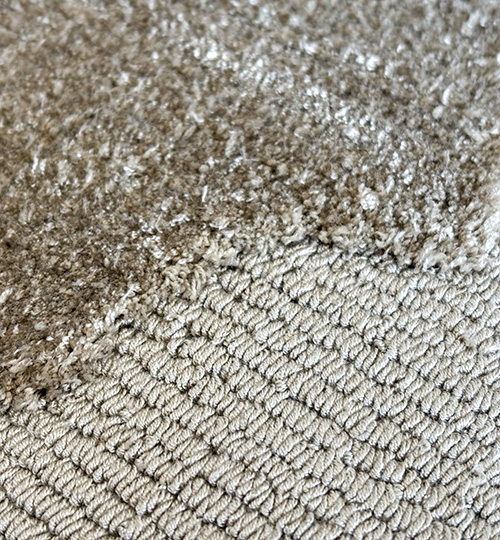 Close-up of tufted rayon rug showing shiny beige loops in uniform rows