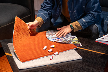 Founder of a custom tufted rug company holding a small rug sample to choose new colors