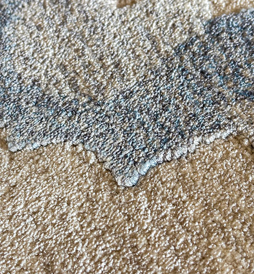 Close-up of tufted bamboo silk rug showing plush texture in blue-gray and beige tones