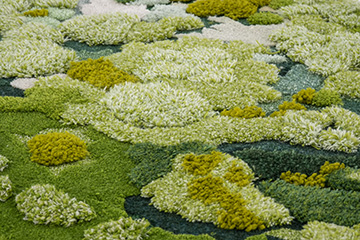 Hand tufted moss rug featuring wool and silk yarn types and multiple pile height variations in forest green